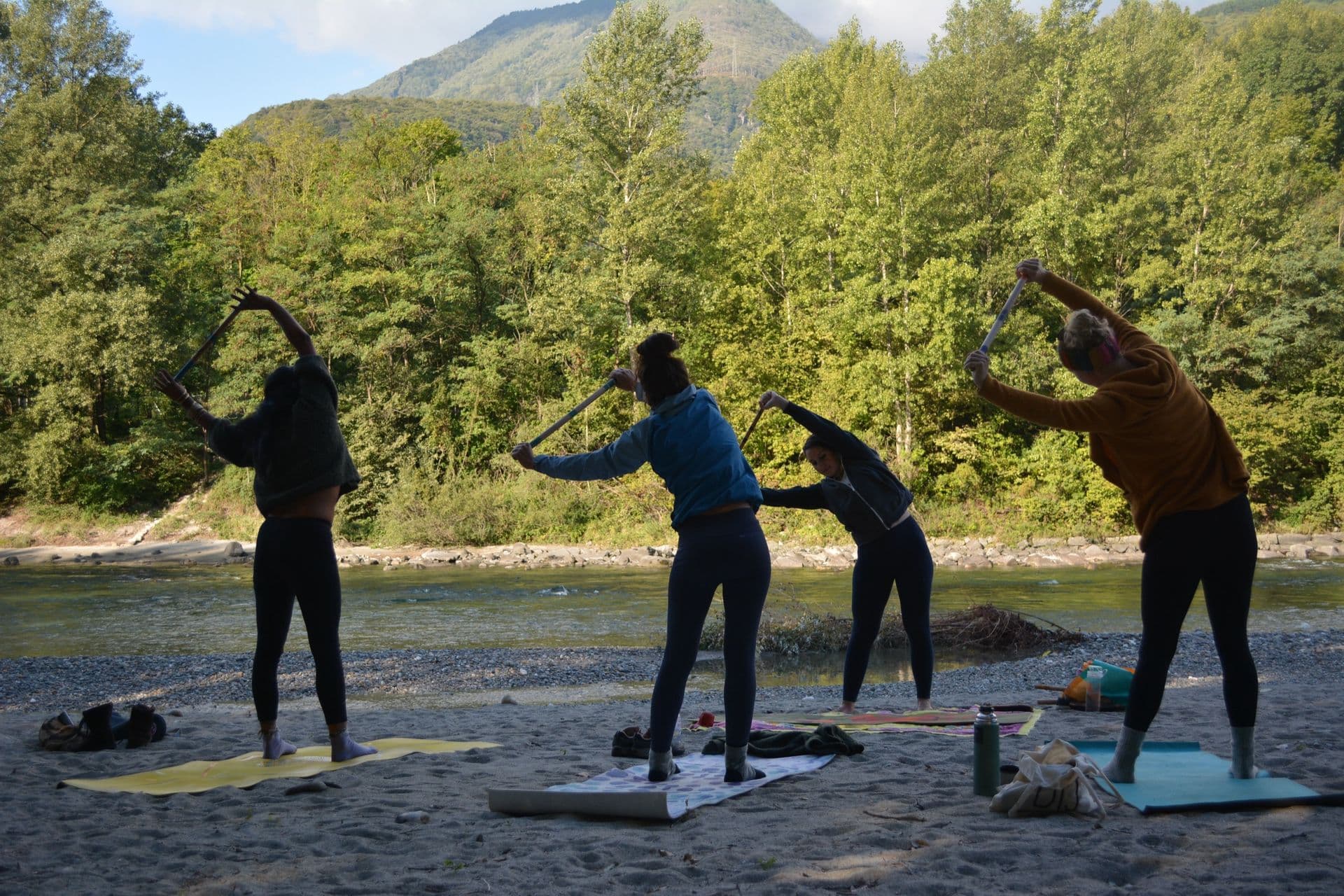Un gruppo in pratica di movimento lungo il fiume, tra le montagne