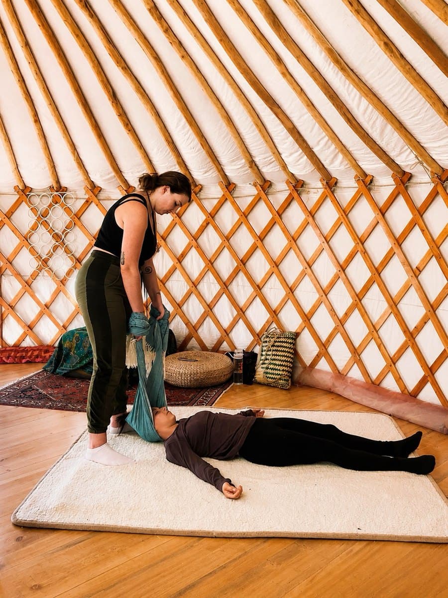 Valentina cradling someone's head with the rebozo
